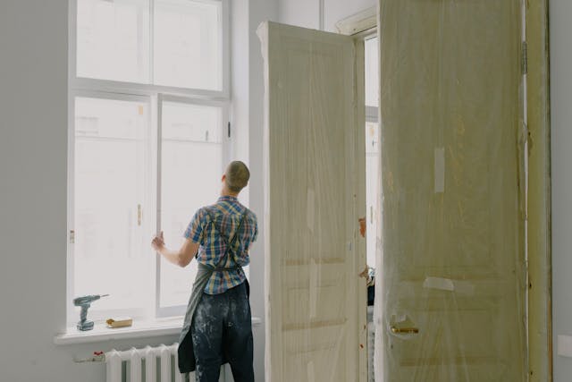 a contractor installing windows in a home