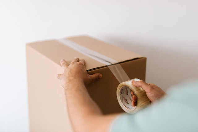a person taping up a moving box